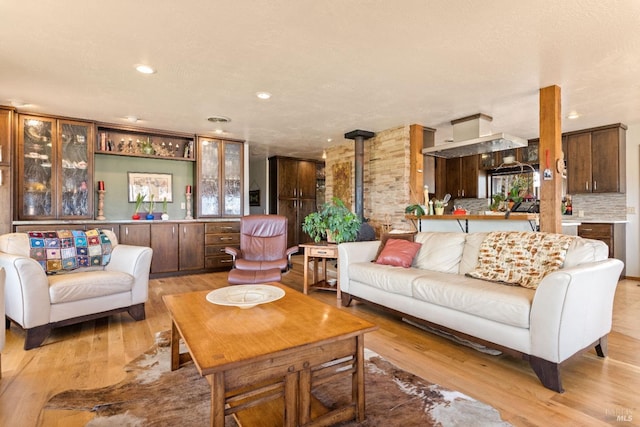 living room with a wood stove and light wood-type flooring