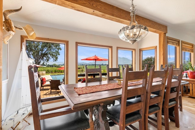 dining area featuring beam ceiling and a chandelier