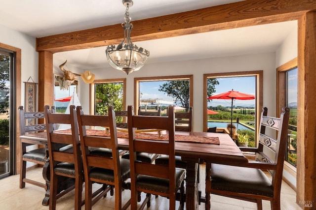 tiled dining space with beamed ceiling and a notable chandelier