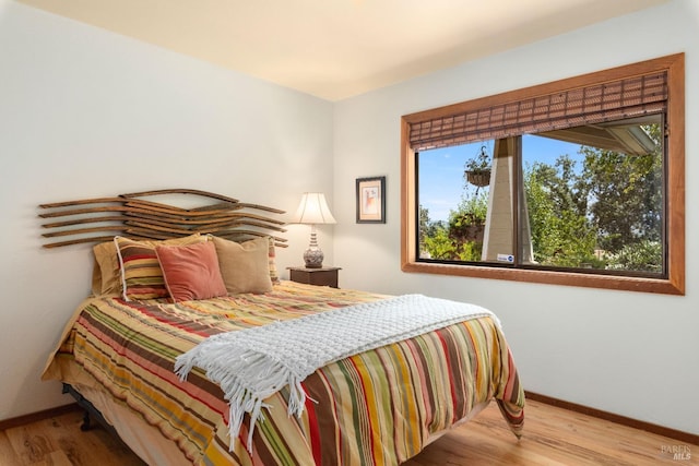 bedroom featuring multiple windows and light wood-type flooring