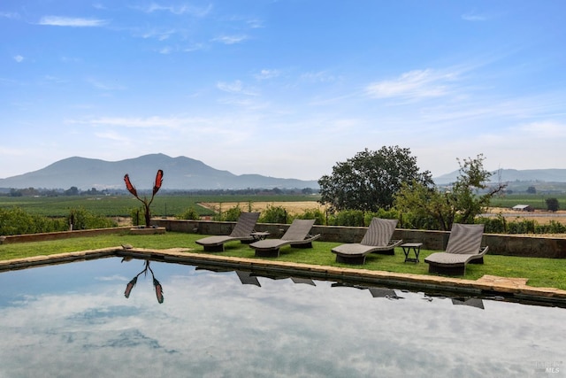 view of home's community with a yard, a mountain view, and a rural view