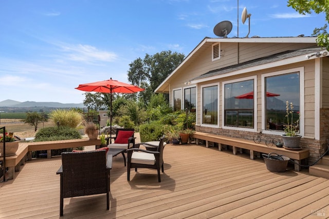 wooden deck featuring an outdoor living space and a mountain view