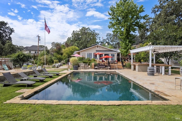 view of pool with an outbuilding, a pergola, a patio area, and a lawn