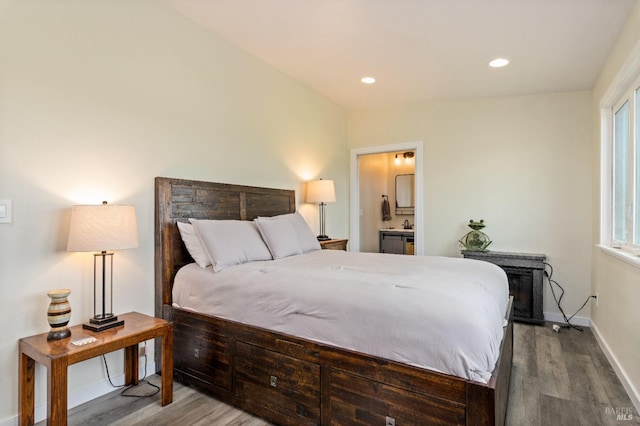 bedroom featuring hardwood / wood-style flooring, connected bathroom, and multiple windows