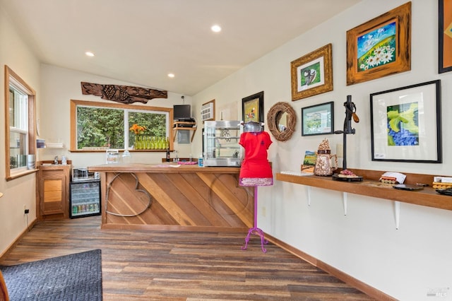 kitchen featuring lofted ceiling, dark hardwood / wood-style flooring, kitchen peninsula, and a breakfast bar area