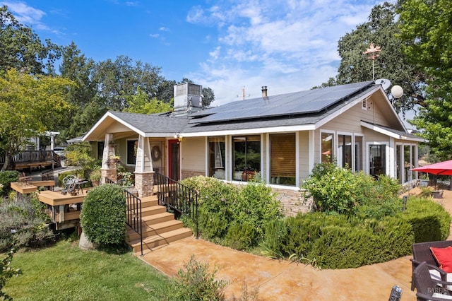 view of front of property featuring solar panels and covered porch