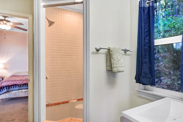 bathroom with a tile shower and ceiling fan