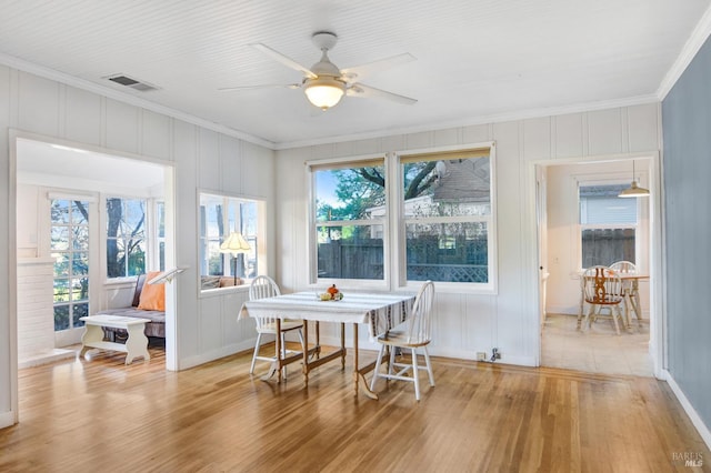 dining area featuring crown molding, ceiling fan, and light hardwood / wood-style flooring