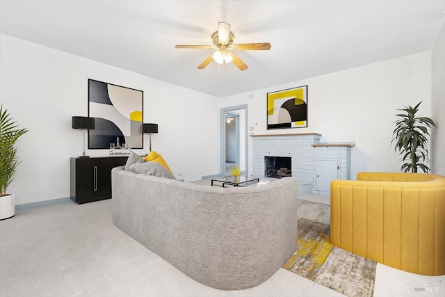 living area featuring carpet flooring, ceiling fan, and a fireplace