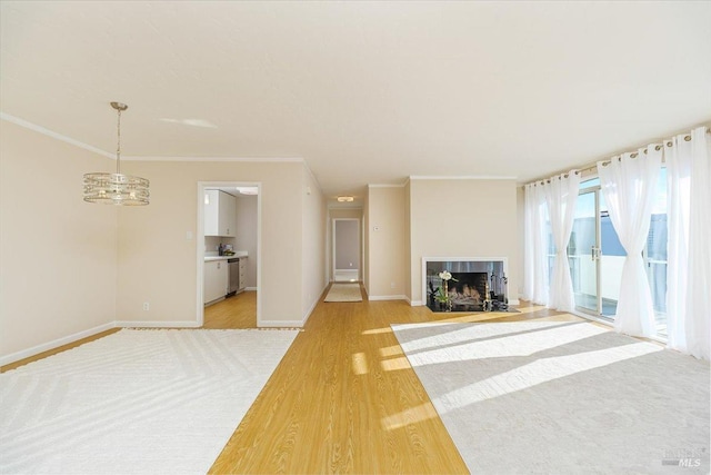 unfurnished living room with a tile fireplace, ornamental molding, and light wood-type flooring