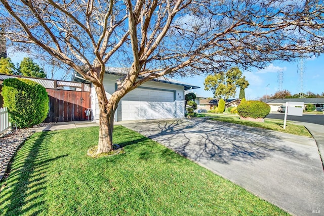 view of front of house with a front yard, an attached garage, fence, and driveway