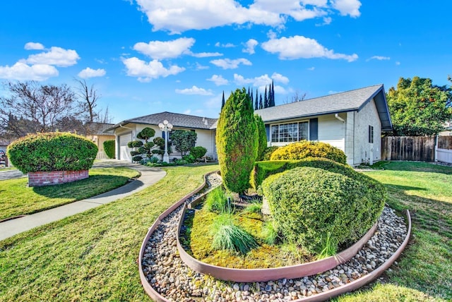 view of front of property with a front yard, an attached garage, and fence