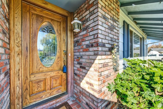 doorway to property featuring brick siding