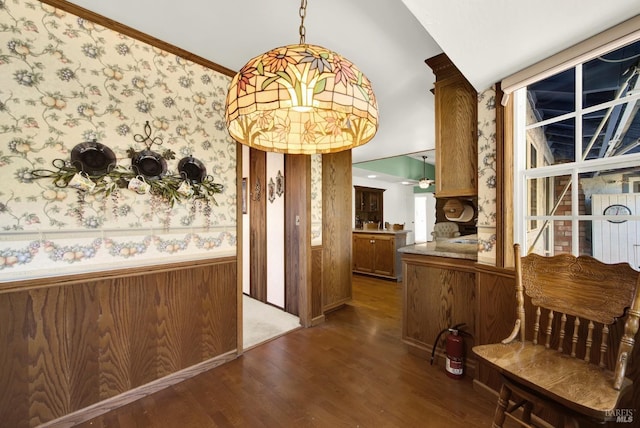 hallway with crown molding, a wainscoted wall, wood finished floors, and wallpapered walls