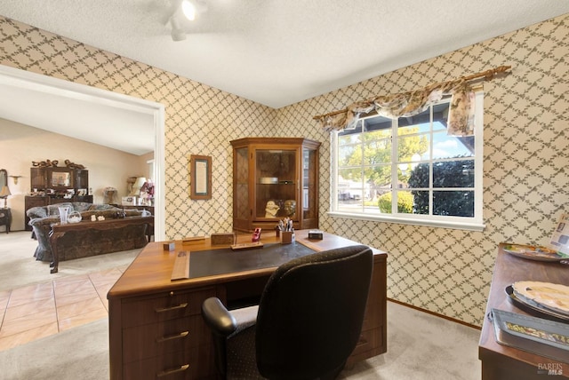 office area with a textured ceiling, lofted ceiling, light carpet, and wallpapered walls