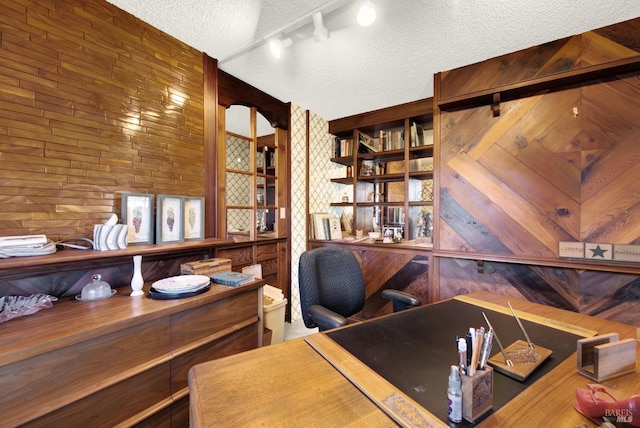 office space with track lighting and a textured ceiling