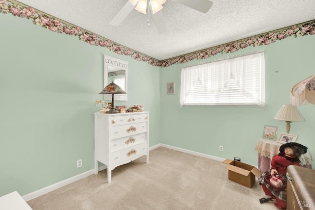 interior space with light carpet, a textured ceiling, baseboards, and a ceiling fan