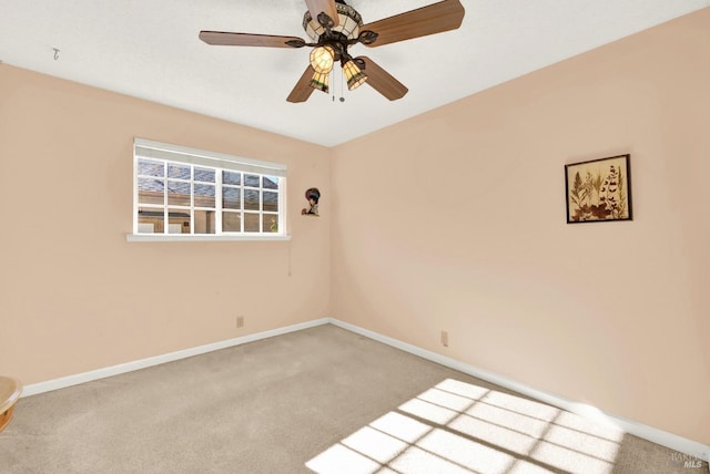 spare room with carpet flooring, baseboards, and ceiling fan