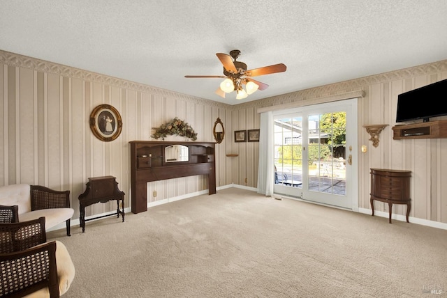 living area featuring ceiling fan, a textured ceiling, and carpet