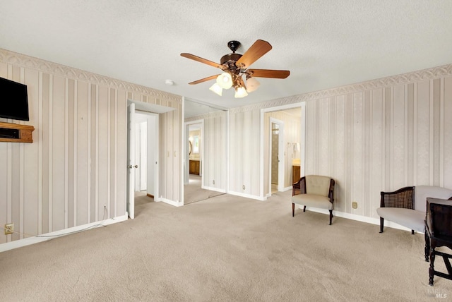 unfurnished room featuring carpet floors, ceiling fan, baseboards, and wallpapered walls
