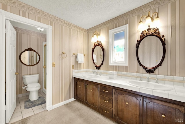 bathroom featuring vanity, tile patterned floors, a textured ceiling, and toilet