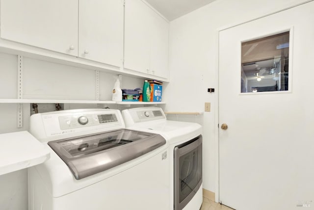 laundry area with washer and clothes dryer, baseboards, and cabinet space