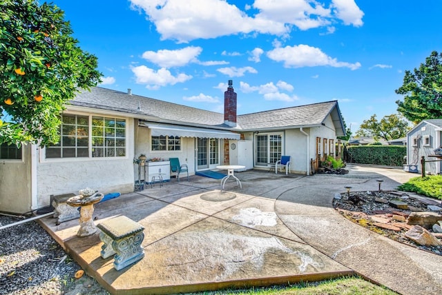 back of house featuring a patio, a chimney, stucco siding, and fence