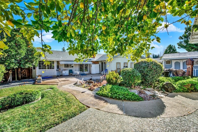 back of property featuring a patio area, stucco siding, fence, and a lawn