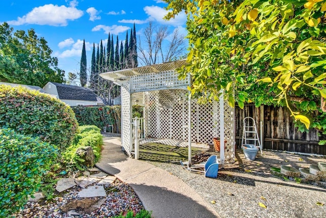 view of outbuilding featuring a pergola and fence