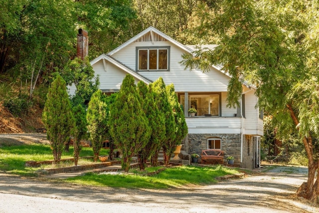 view of front of house featuring stone siding and a chimney