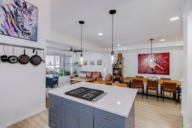 kitchen featuring recessed lighting, light wood-style floors, open floor plan, light countertops, and pendant lighting