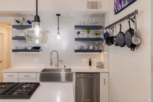 kitchen featuring decorative light fixtures, open shelves, visible vents, white cabinets, and a sink