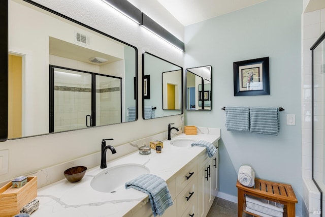 bathroom featuring double vanity, a sink, visible vents, and a shower stall