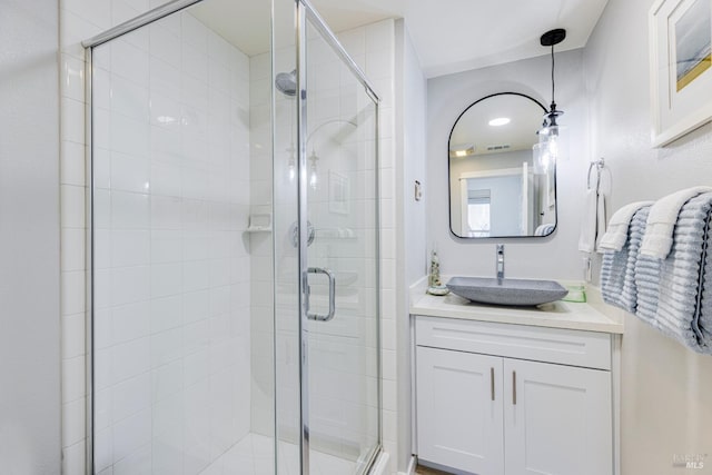 bathroom featuring a shower stall, visible vents, and vanity