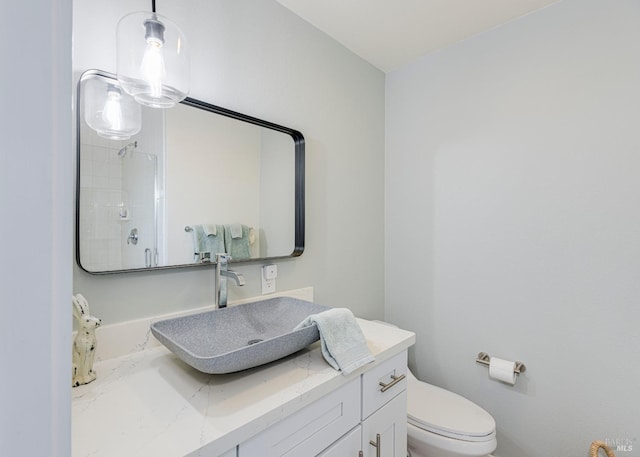 bathroom featuring toilet, walk in shower, and vanity