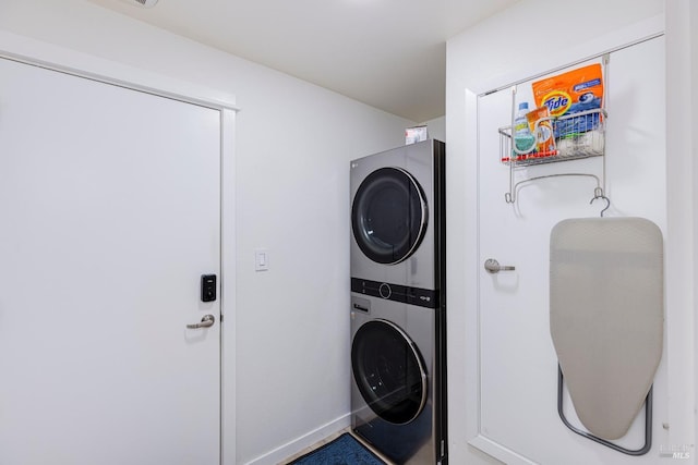 laundry room featuring laundry area, baseboards, and stacked washer and clothes dryer