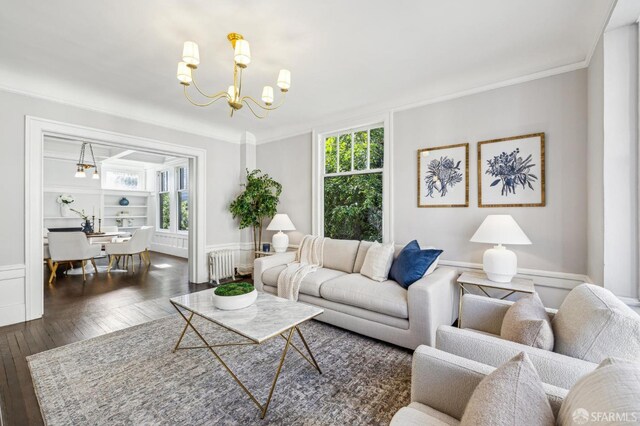 living room with dark hardwood / wood-style flooring, a notable chandelier, crown molding, and radiator heating unit