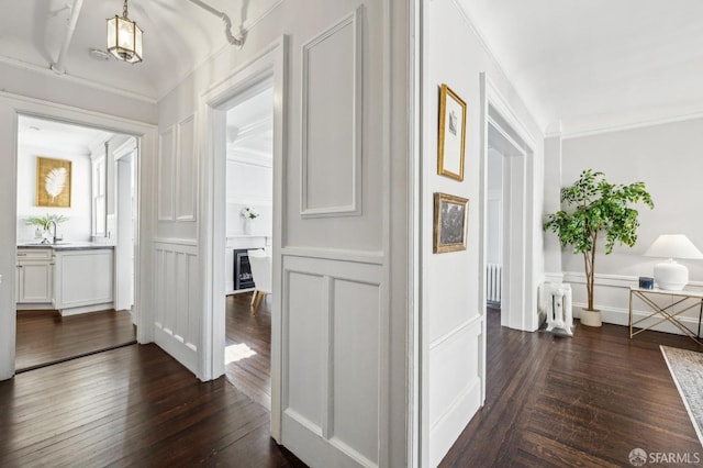 corridor with crown molding, sink, and dark hardwood / wood-style flooring