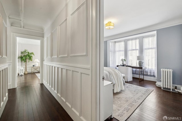 hall with dark wood-type flooring and radiator