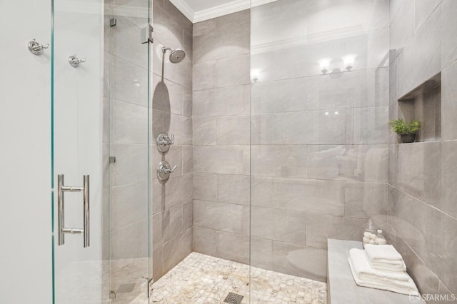 bathroom with ornamental molding and a shower with door