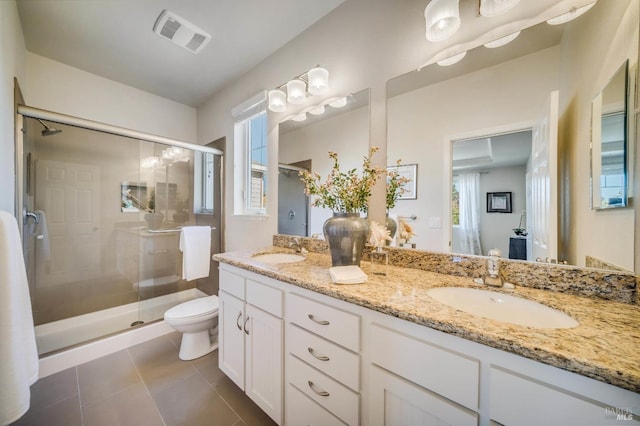 bathroom featuring vanity, toilet, a shower with shower door, and tile patterned flooring