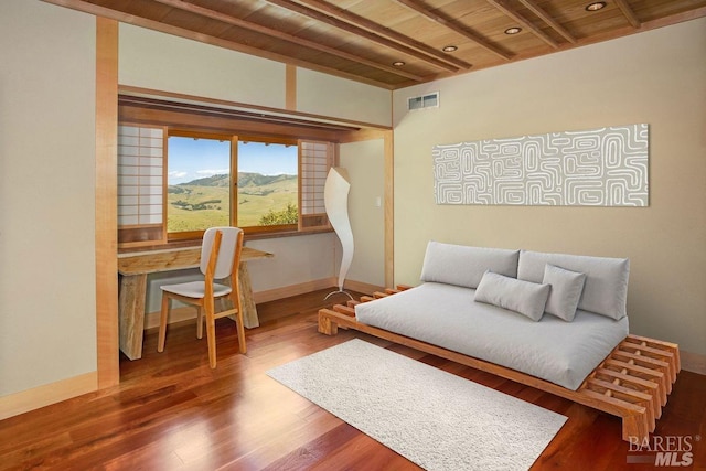 bedroom featuring hardwood / wood-style floors, wood ceiling, a mountain view, and beamed ceiling