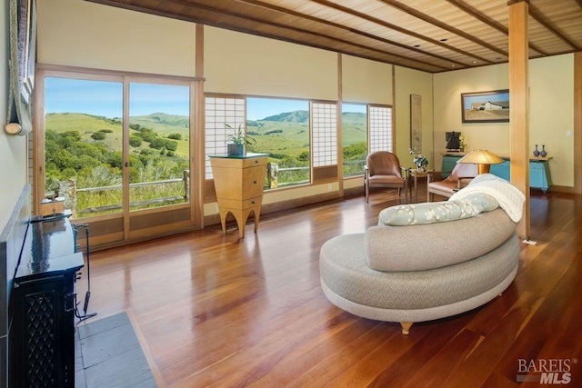 sunroom featuring a mountain view and wooden ceiling