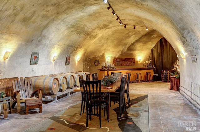 dining space with vaulted ceiling, brick ceiling, and track lighting