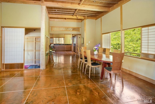 dining space featuring beamed ceiling