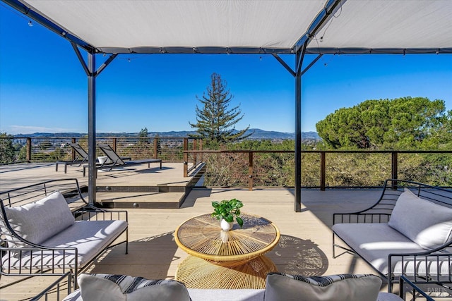 view of patio / terrace with an outdoor living space and a deck with mountain view