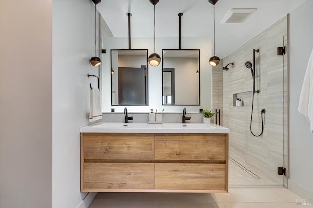 bathroom with an enclosed shower, vanity, and tile patterned floors