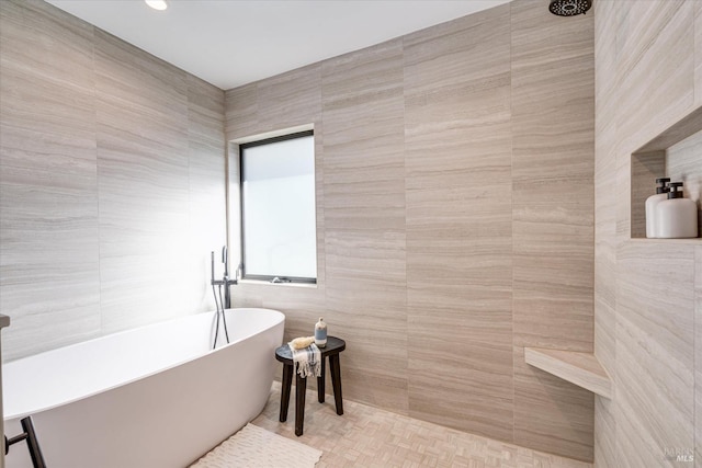 bathroom featuring tile walls and a tub to relax in