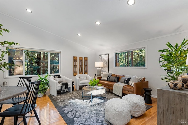 living room featuring lofted ceiling, hardwood / wood-style flooring, crown molding, and a healthy amount of sunlight