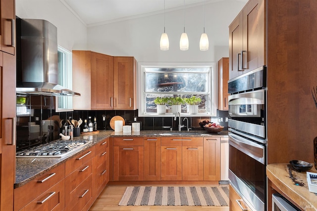 kitchen with wall chimney exhaust hood, dark stone counters, ornamental molding, stainless steel appliances, and decorative backsplash